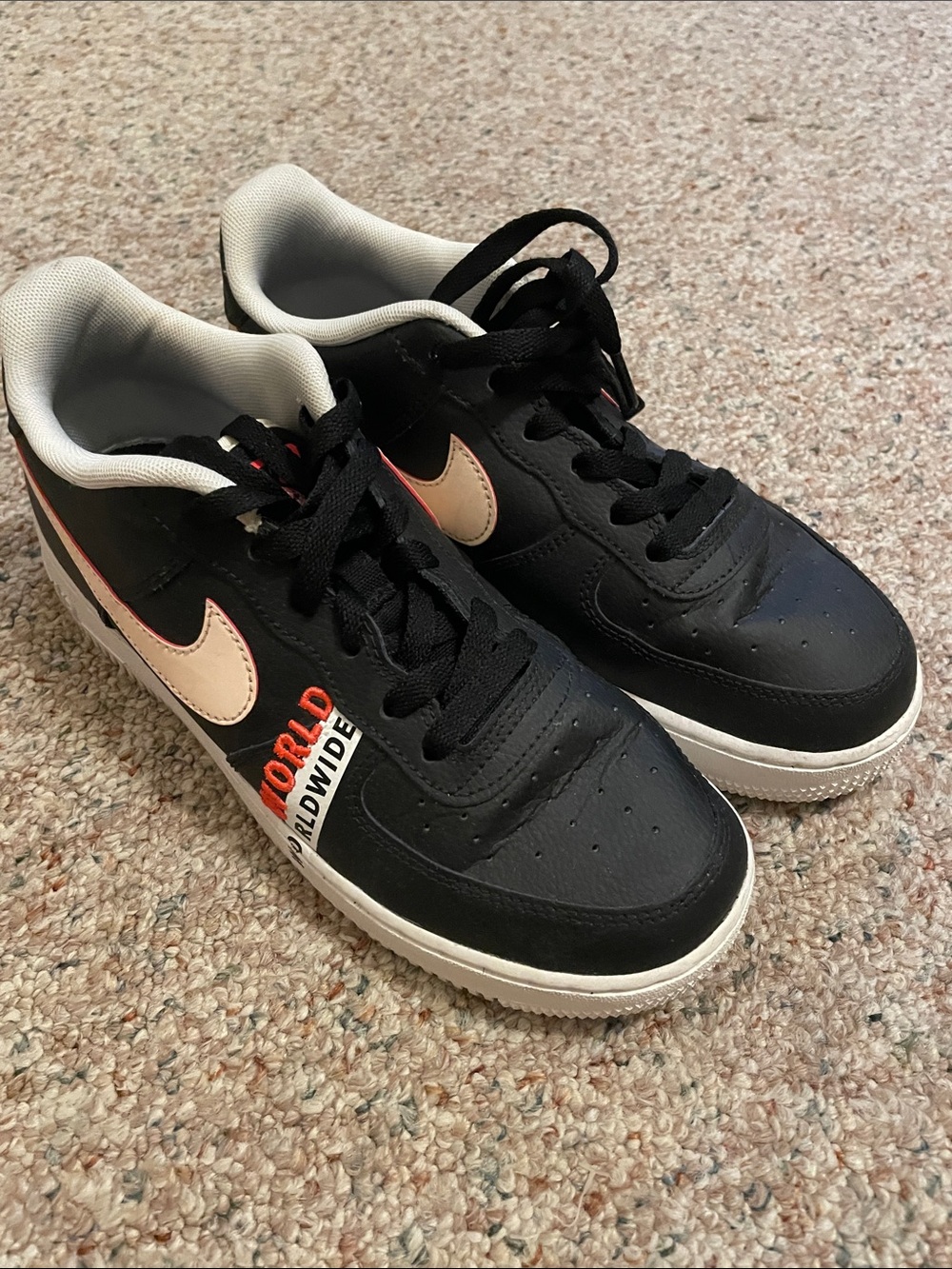 Nike Kids Black Sneakers with Cream Swoosh and Orange Accents